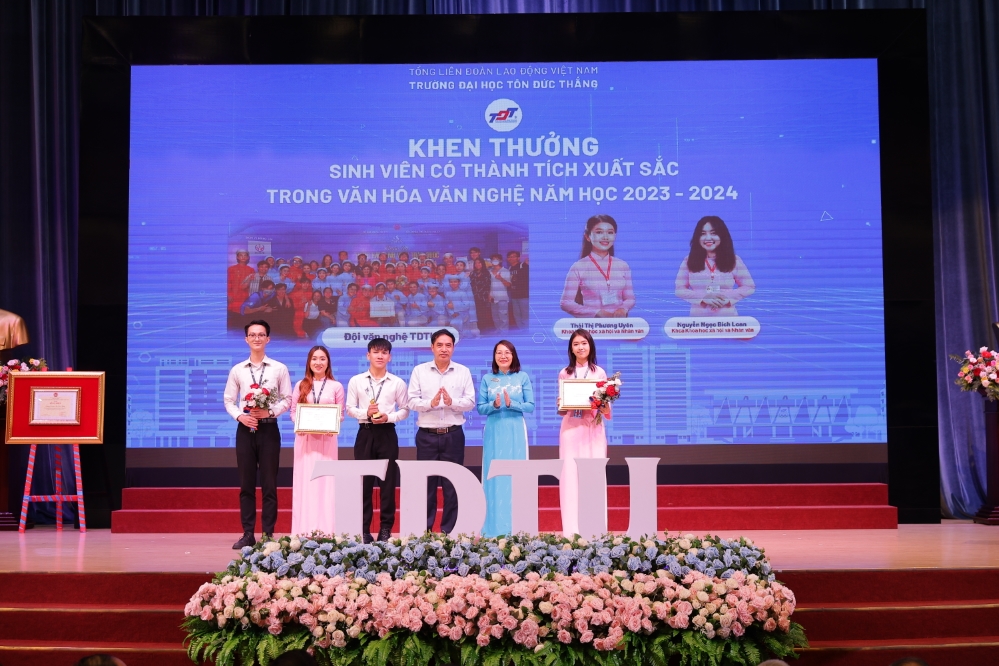 Dr. Vu Trong Binh, Director General of the Department of Employment, and Assoc. Prof. Dr. Pham Thi Minh Ly, Vice Chairwoman of the University Council, presenting awards to students for their outstanding achievements in culture and the arts