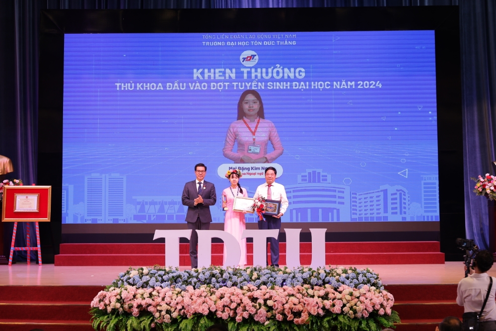 Dr. Tran Trong Dao, President of TDTU, presenting an award to the new valedictorian, Mai Dang Kim Ngoc, and giving a token of appreciation to the representative of the Board of Management of Hoang Dieu High School in Soc Trang Province