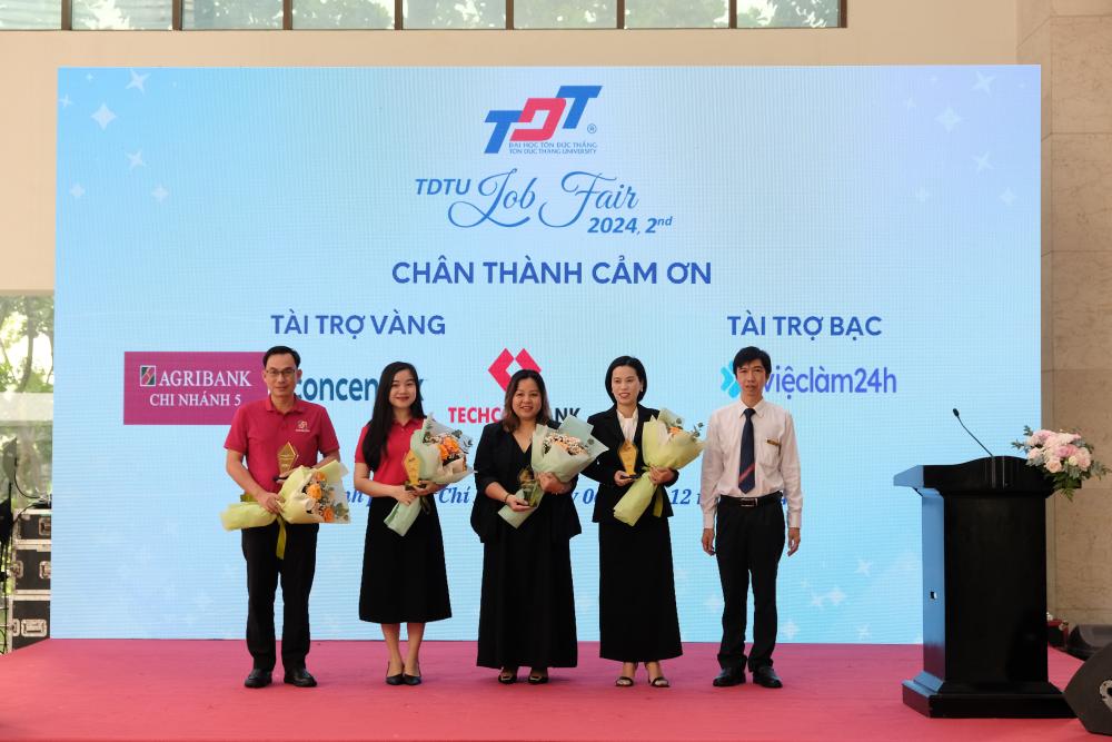 Dr. Vo Hoang Duy, Vice President of TDTU, presenting flowers and gifts to the silver sponsors