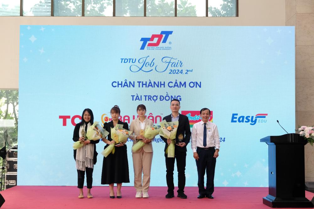 Mr. Tang Khac Quy, Director of the Center of Enterprise Cooperation and Alumni at TDTU, presenting flowers and gifts to the bronze sponsors