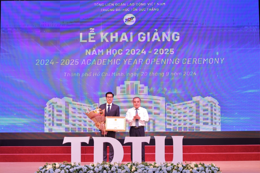 Mr. Tran Hoang Tuan, Permanent Vice Chairman of the Quang Ngai Provincial People's Committee, presenting the Certificate of Merit from the Quang Ngai Provincial People's Committee to the University