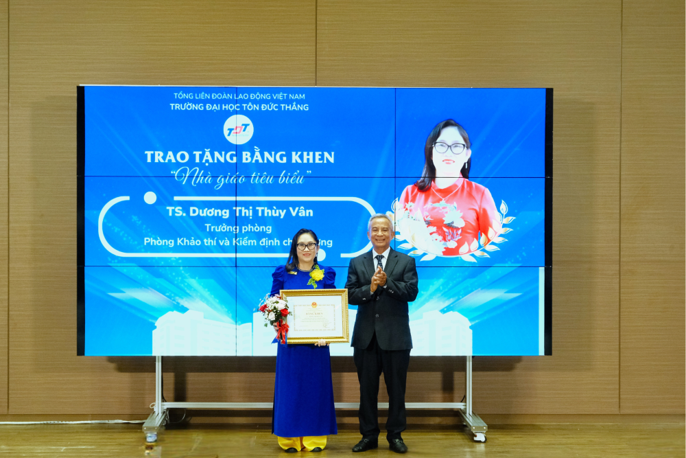 TS. Đặng Ngọc Tùng – Nguyên Ủy viên Trung ương Đảng, nguyên Chủ tịch Tổng Liên đoàn Lao động Việt Nam, thành viên Hội đồng trường trao bằng khen “Nhà giáo tiêu biểu” năm 2024 và tặng hoa chúc mừng cho TS. Dương Thị Thùy Vân – Trường phòng Phòng Khảo thí và Kiểm định chất lượng