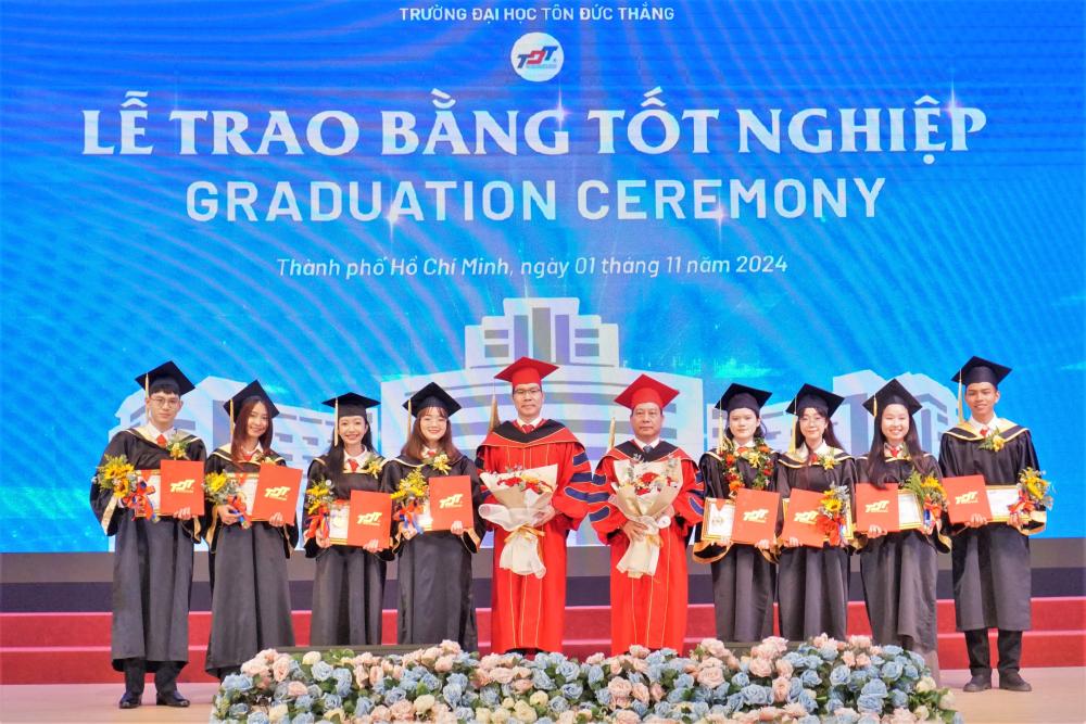 Các tân khoa tặng hoa tri ân thầy cô Lãnh đạo Nhà trường (trong ảnh: TS. Vũ Anh Đức – Chủ tịch Hội đồng Trường, hình bên phải và TS. Trần Trọng Đạo, Hiệu trưởng TDTU, hình bên trái)