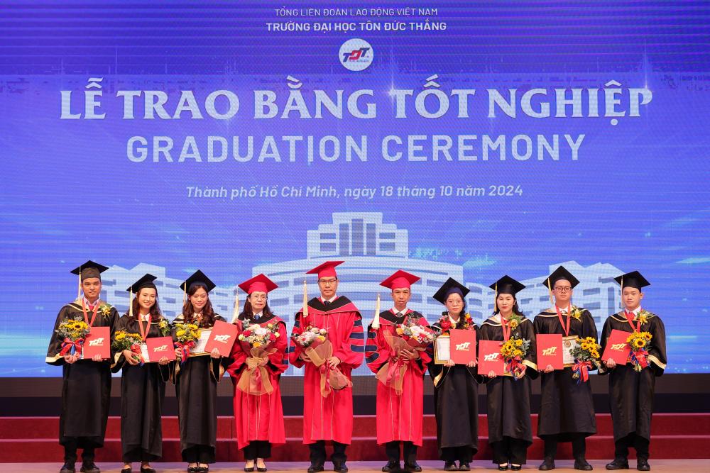 New graduates giving flowers to the Presidential Board